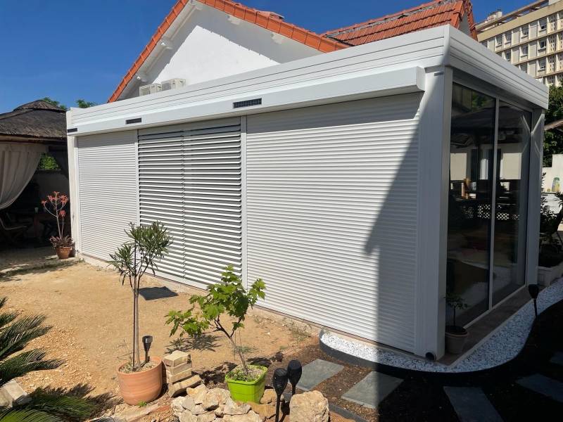 Veranda avec volets roulants à lames orientables